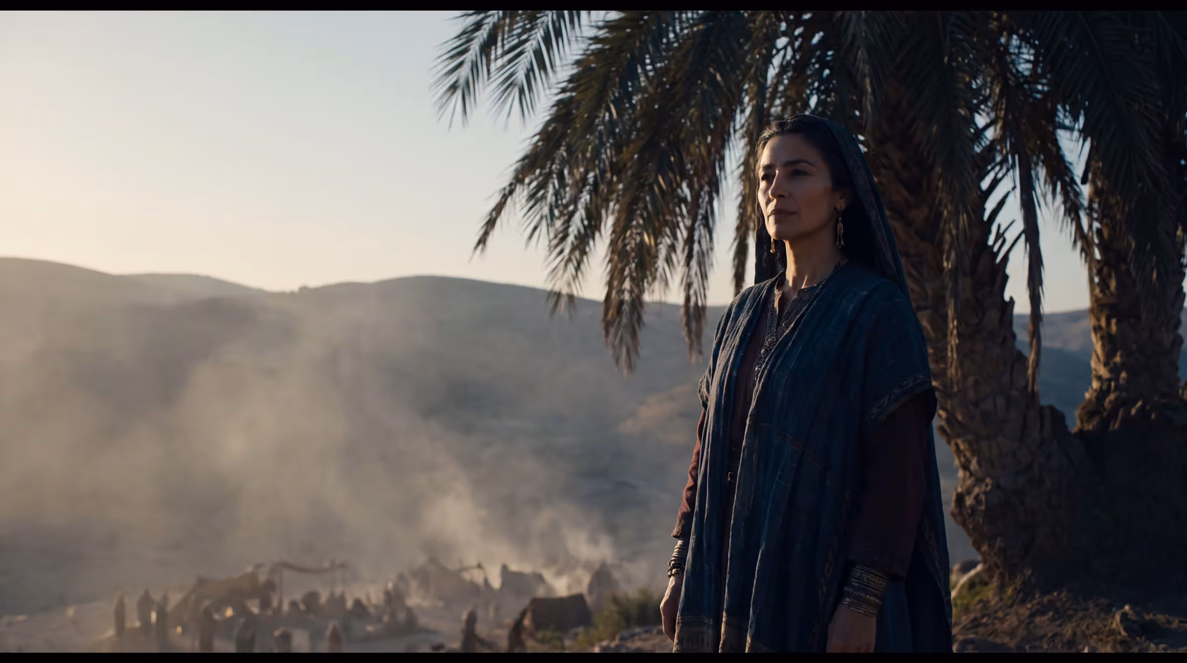Deborah beneath an ancient palm on a ridge in Ephraim at first light, looking out over a valley with an army far below